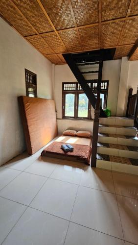 TimbanglawangWhite house Sumatra Bukit Lawang的一间带床的卧室,位于带楼梯的房间