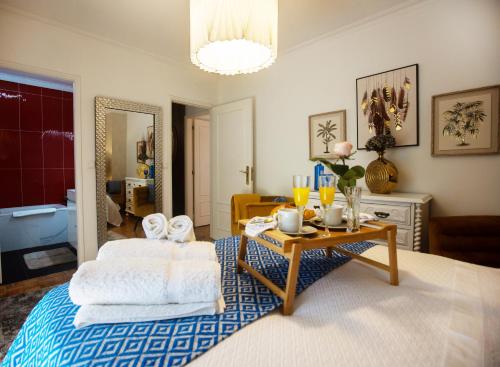 布拉加Maria Home Reall's的一间卧室配有一张床、一张桌子和毛巾