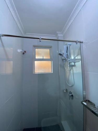 KiambuTodas Hotel的浴室设有玻璃淋浴间和窗户