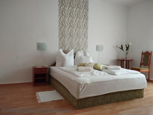 久洛Bányai Apartman的一间卧室配有一张带白色床单的大床