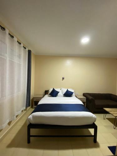 KiambuTodas Hotel的一间卧室配有一张大床和一张沙发