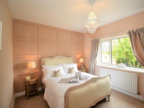 Dearham3 Bed in Cockermouth 82438的一间卧室设有一张床、一个窗户和一个吊灯。