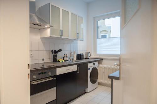 汉诺威Modernes Apartment 4 Personen Zentral 56qm WLAN gehobene Ausstattung的厨房配有水槽和洗衣机