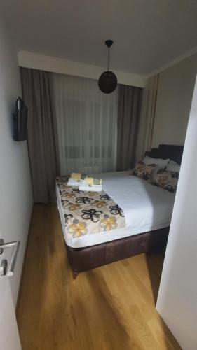 RebrovacApartman ADA Banja Luka的一间卧室配有一张带鲜花的大床