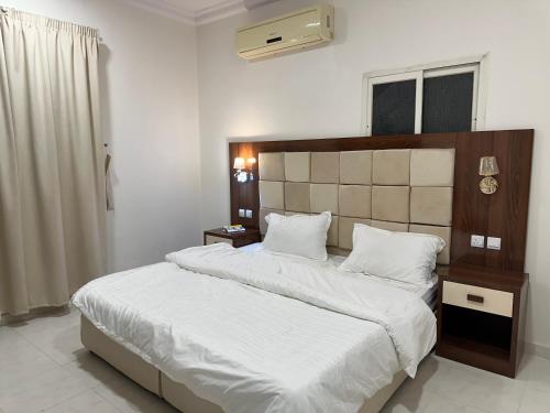 哈费尔巴廷Dorat alsafaa的一间卧室配有一张带白色床单的大床