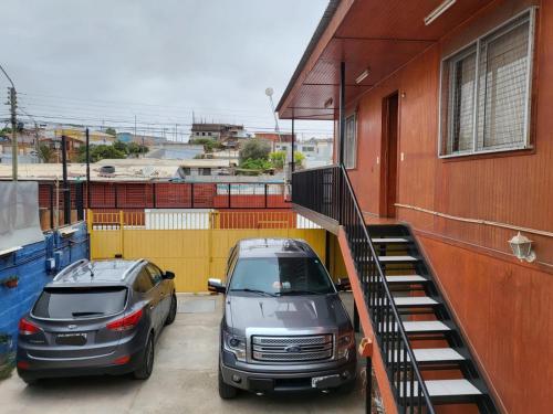卡尔德拉Hostal aleja的两辆汽车停在大楼旁边的停车场