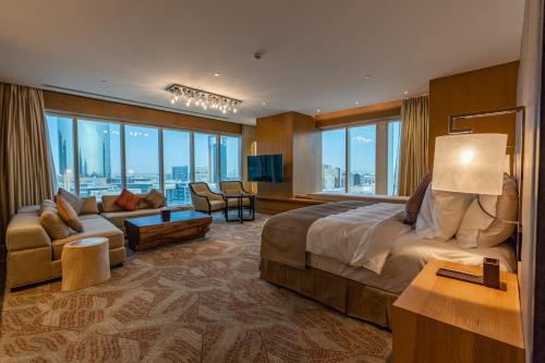 利雅德Al Anoud Tower Residence的大型酒店客房,配有床和沙发