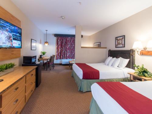 昆斯伯里Six Flags Great Escape Lodge & Indoor Waterpark的酒店客房设有两张床和一台平面电视。