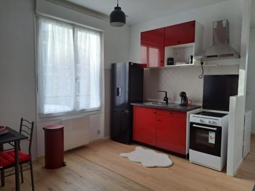 普瓦捷Confortable Apart de 3 pièces的厨房配有红色橱柜和黑色冰箱