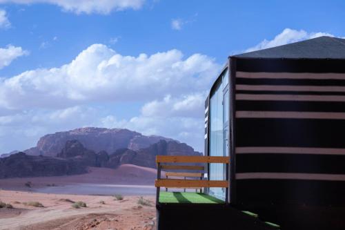 瓦迪拉姆Desert Sand Camp的坐在沙漠火车边的长凳
