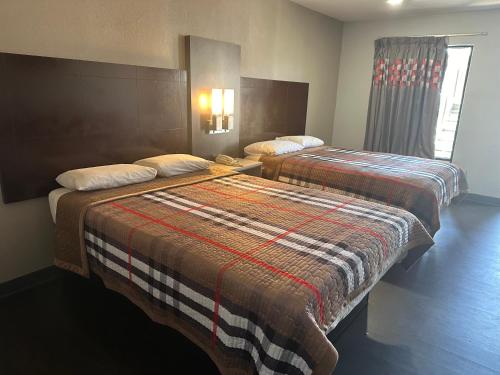 奥古斯塔Scottish Inn Augusta downtown的酒店客房设有两张床和窗户。