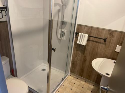 奥克兰Conway Motel Manukau的带淋浴、卫生间和盥洗盆的浴室