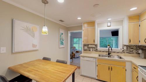 杰基尔岛BEACHY SISTERS A Duplex的厨房配有木桌和水槽。