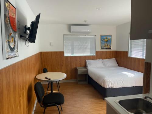 奥克兰Conway Motel Manukau的小房间设有床、桌子和水槽