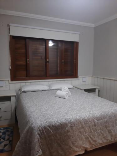 格拉玛多Solar das Esmeraldas - Apto 105的一间卧室配有一张床,上面有两条毛巾