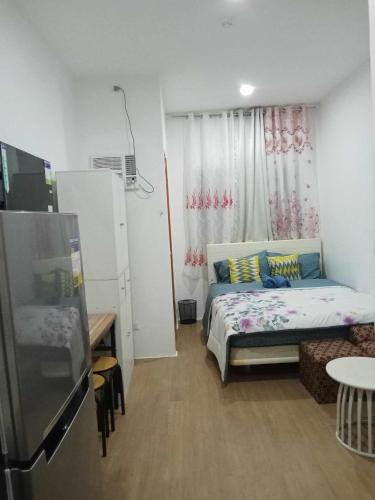Lapu Lapu CityAle Contel的小房间设有一张床和一台冰箱