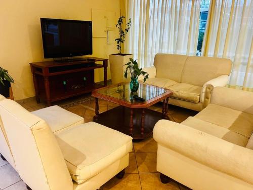 雷孔基斯塔HOTEL LOS TILOS RECONQUISTA的客厅配有白色家具和电视