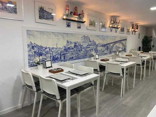 波尔图Guest House Triunfo的用餐室配有白色的桌子和白色的椅子