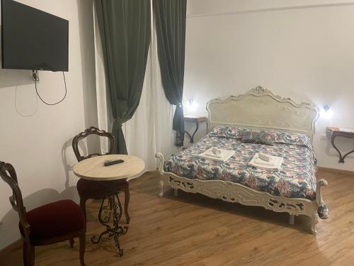 热那亚凯沃尔16号住宿加早餐旅馆的一间卧室配有一张床、一张桌子和一台电视。