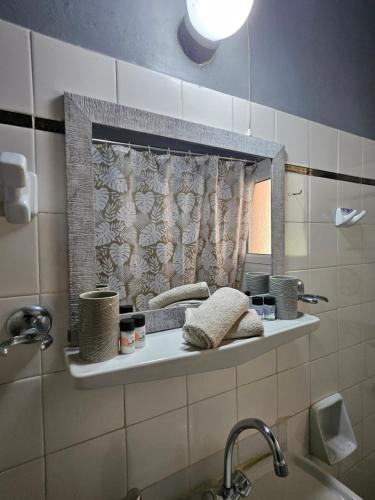 Alykes PotamouHouse with yard的浴室设有水槽和架子上的镜子