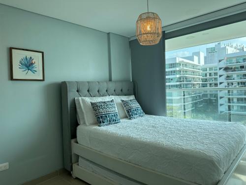 卡塔赫纳Luxury Morros Seaway Cartagena的一间卧室设有一张床和一个大窗户