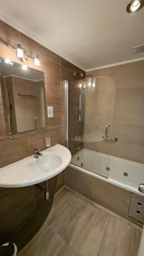马德普拉塔Hotel Novi的浴室配有水槽、淋浴和浴缸。