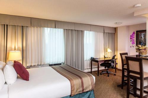 埃德蒙顿堪帕斯大楼套房酒店的配有一张床和一张书桌的酒店客房