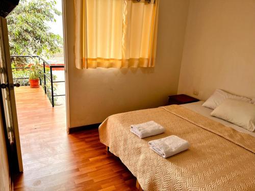 利马Samanai Wasi Hostel的一间卧室配有一张床,上面有两条毛巾