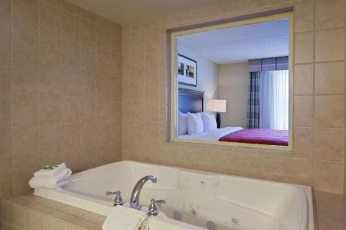 弗雷德里克斯堡Country Inn & Suites by Radisson, Fredericksburg, VA的一间带浴缸和大镜子的浴室