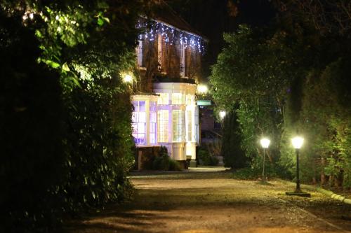 皇家伍顿巴西特玛希农场酒店的夜间用圣诞灯点亮的房子