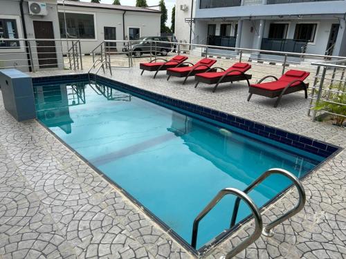 阿布贾Checkers Suite & Apartments的一个带红色椅子的游泳池