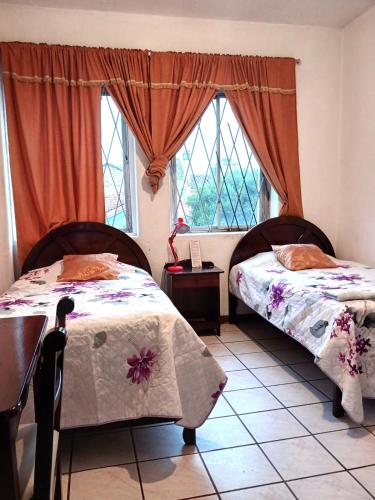基多Hostal Almagro的带2扇窗户的客房内的2张床