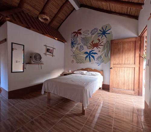 马祖特Casa H Rinconcito Mazunte的一间卧室设有一张床和鲜花墙