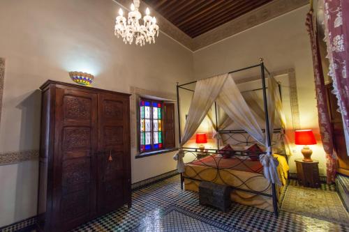 非斯里亚德诺玛庭院旅馆的一间卧室配有一张床和一个吊灯