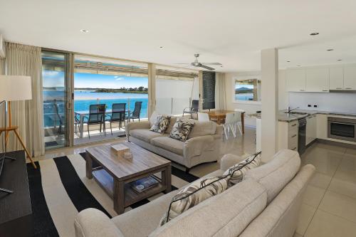 努萨角努沙港湾度假酒店的带沙发和桌子的客厅以及厨房。