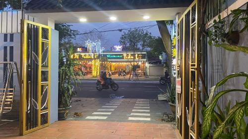 岘港CÁT TƯỜNG MOTEL的骑摩托车穿过敞开的门的人