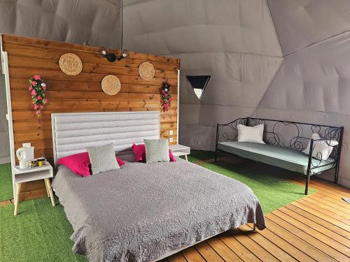 珀蒂蒂勒Domaine de l'Anse的一间卧室配有一张床,帐篷内设有一个长凳