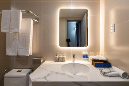 富国The Up Phu Quoc的一间带水槽、镜子和卫生间的浴室