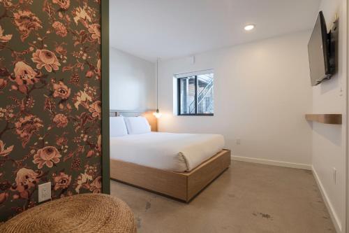 里诺Best Bet Motor Lodge的一间卧室设有一张床和鲜花墙