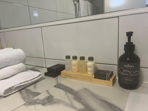 德纳姆鲨鱼湾海瑞泰度假酒店的浴室提供4瓶肥皂和镜子