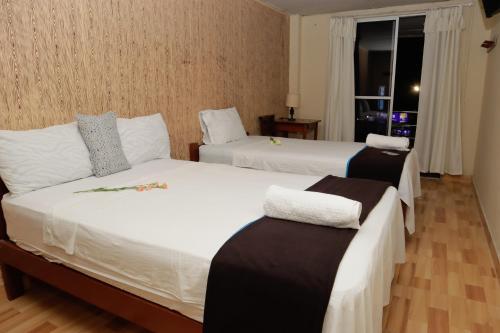 Nueva CajamarcaIrigoin Hospedaje的酒店客房设有两张床和窗户。