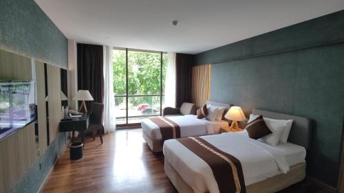 秾莎巴塔姆海景假日酒店的酒店客房设有两张床和窗户。