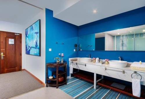 金边Jaya Suites Hotel的浴室设有两个水槽和蓝色的墙壁。