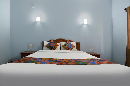 瓦加托FabHotel Prime 4D's Coast Resort的卧室配有一张带两个枕头的大白色床