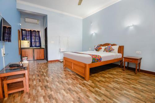 瓦加托FabHotel Prime 4D's Coast Resort的一间卧室配有一张床和一张桌子