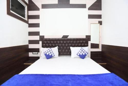 瓦拉纳西GRG Ashiyana Palace Parade Kothi Road Varanasi的一间卧室配有蓝色和白色床单