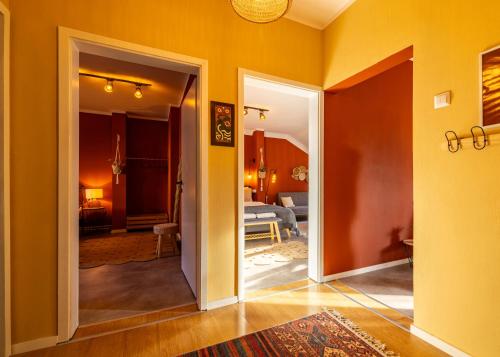 普里什蒂纳Cozy Main Square Apartment的通往客厅的开放式门廊,客厅拥有黄色的墙壁