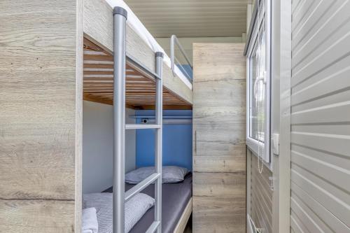 TrebnjeRooftop Home With Whirlpool & Sauna的小房子里的小房间,配有双层床