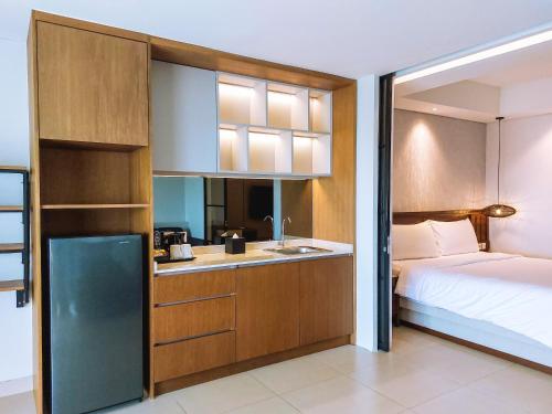 努沙杜瓦Pearl Nusa Dua Suite的一间卧室配有一张床,厨房配有水槽