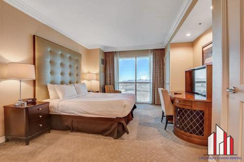 拉斯维加斯MGM Signature-37-814 1Br 2Ba F1 Pits View Balcony的酒店客房配有一张床、一张书桌和一台电视。
